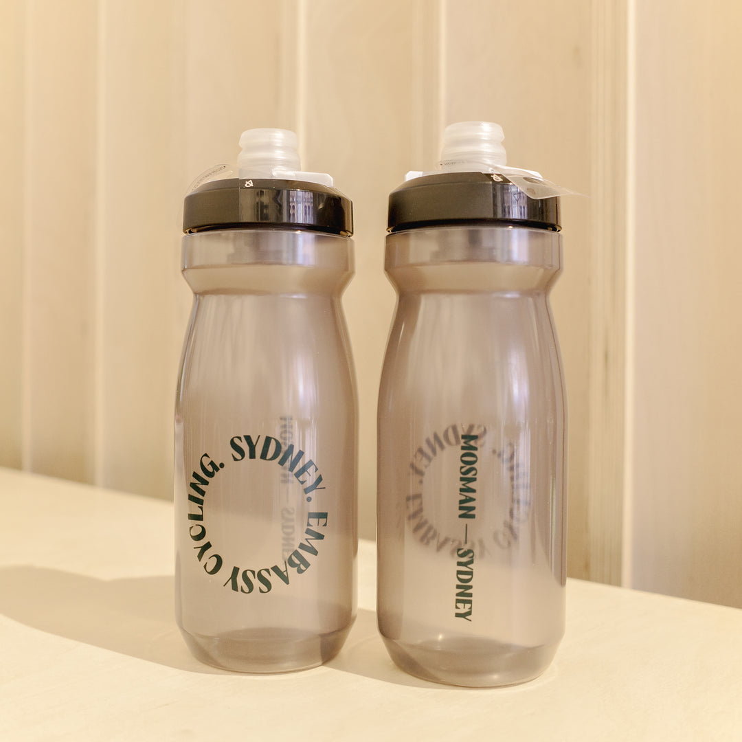 Two clear water bottles with black text on a beige background